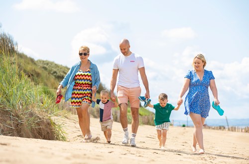 family walking in the sandy beach